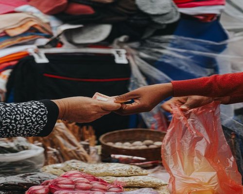 Person buying vegetables in a lively local market in Piura